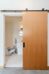 Porte en bois d'une salle de bain adaptée, exemple d'aménagement pour un logement senior
