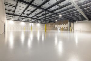 Revêtement de sol professionnel en béton poli dans un entrepôt industriel vide